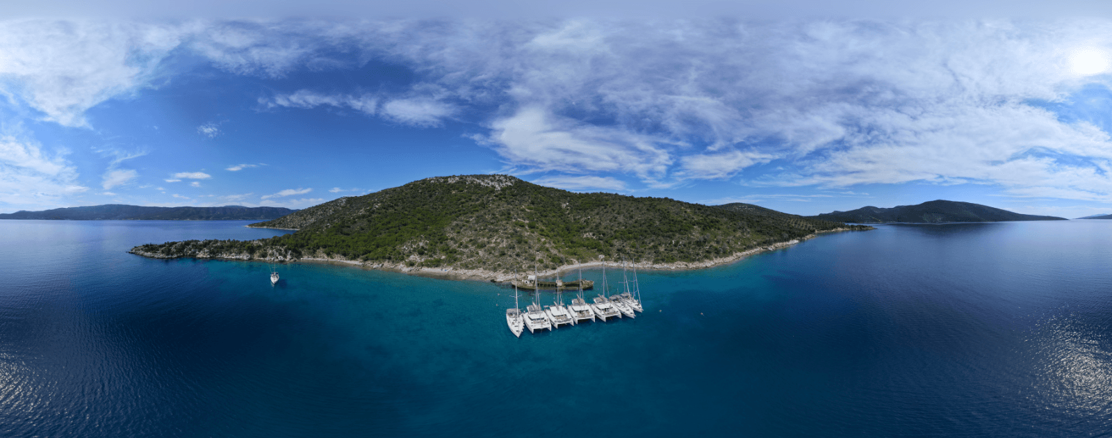 NorthSailing yachts participating in the Bonus Miles Sailing Flotilla in a scenic Greek bay.