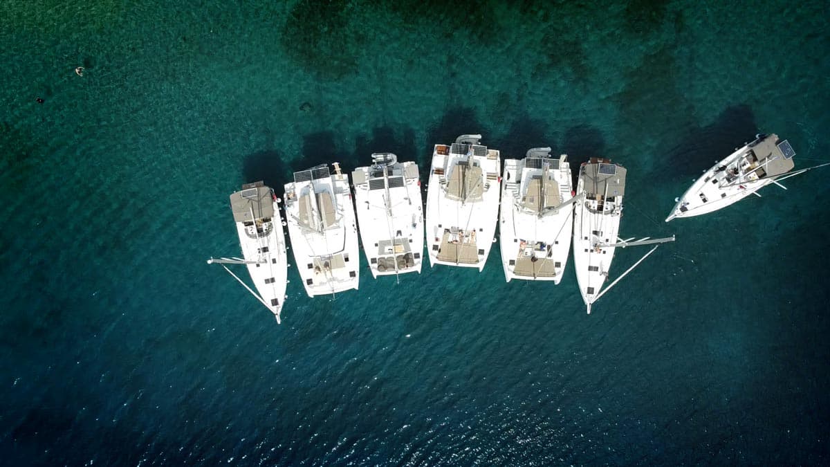 Aerial view of NorthSailing flotilla yachts anchored in clear blue water